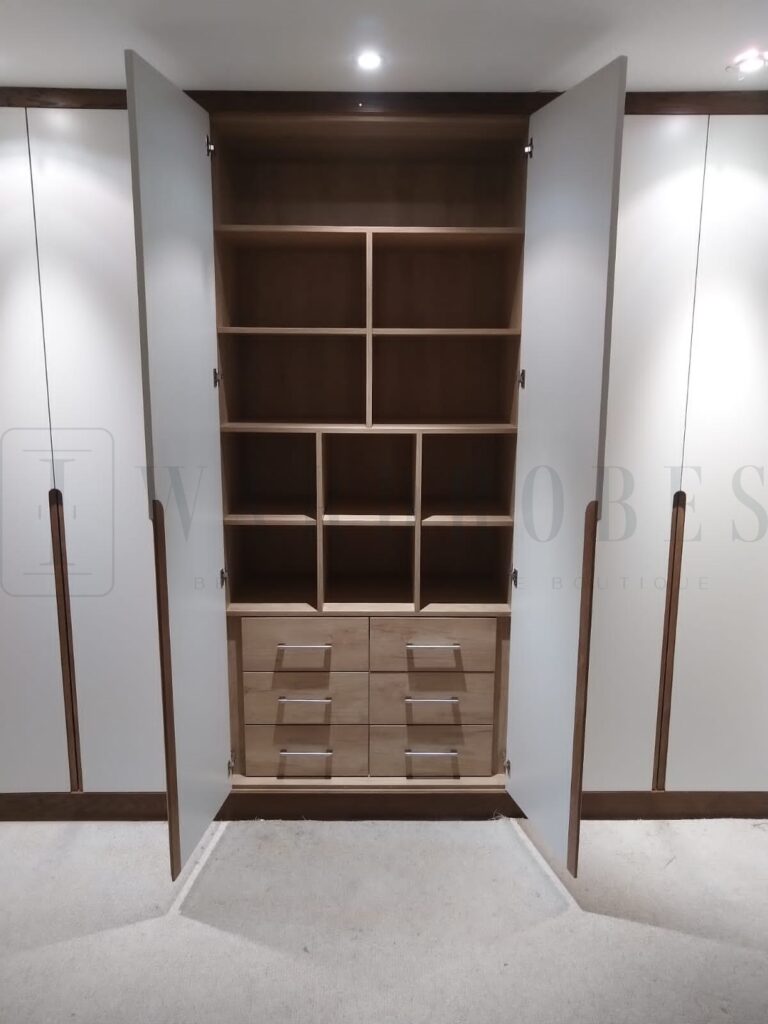 Bespoke white spray painted wardrobe with wooden handles and internal compartments.