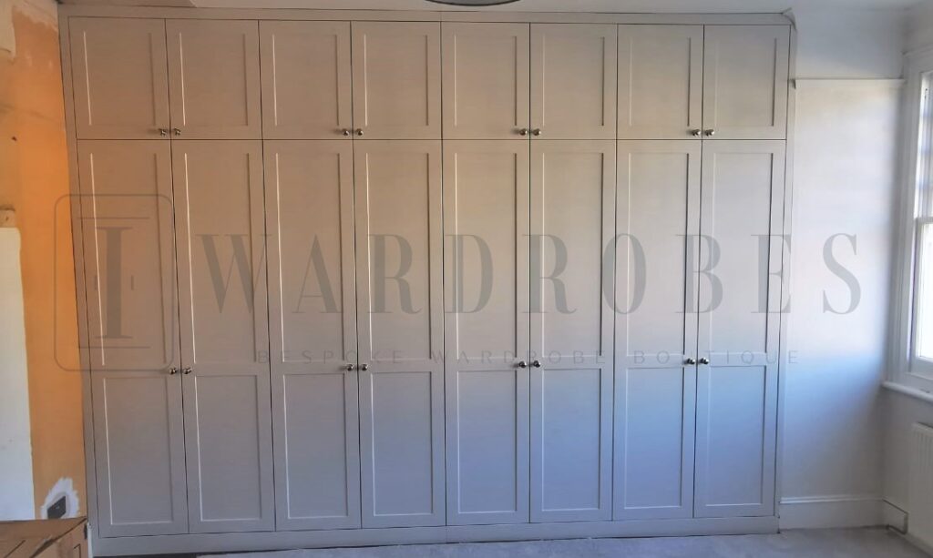 Bespoke shaker style spray painted wardrobe in a modern bedroom.