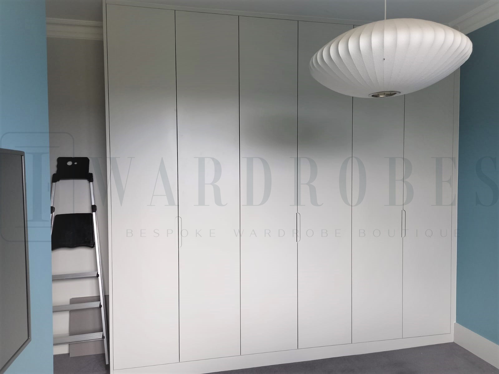 Small routed handle doors wardrobe in a modern bedroom setting.