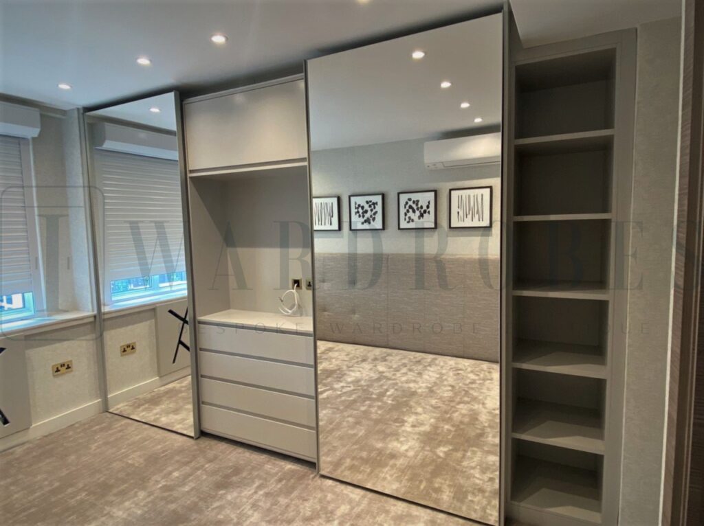 Modern fitted wardrobe with sliding mirror doors in a contemporary bedroom.
