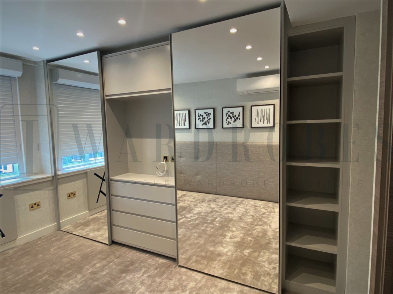 Modern fitted wardrobe with sliding mirror doors in a contemporary bedroom.